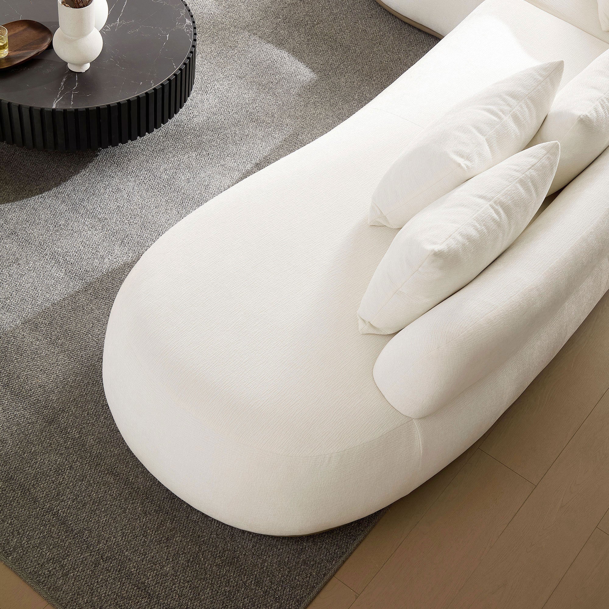 Top view of the chaise section of the L-shape sectional sofa in beige, highlighting its smooth curves and soft cushion design.