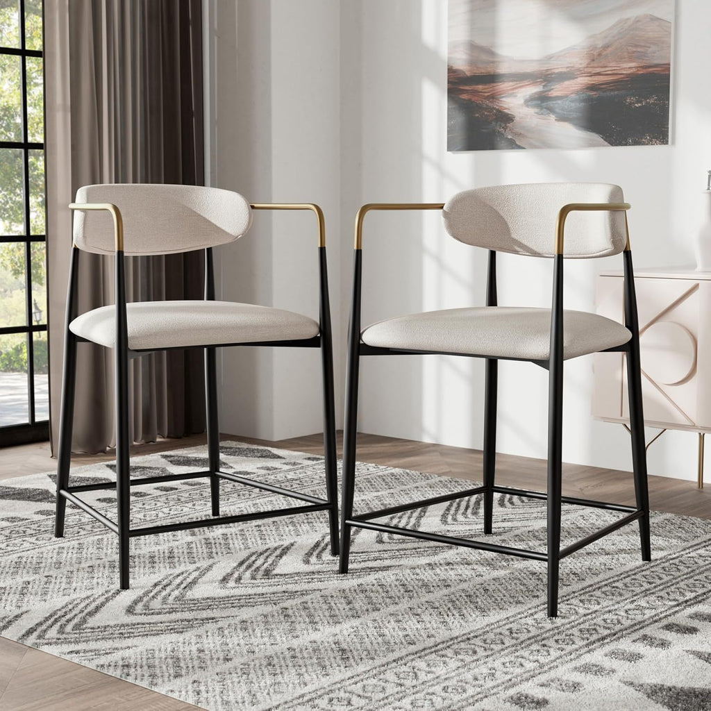 Set of two contemporary counter height chairs with black metal legs, gold accents, and cushioned seats in a modern dining room.