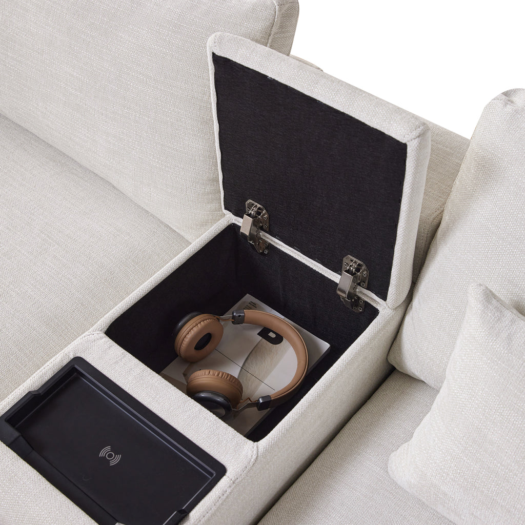 Storage console of L-Shaped sectional sofa shown open with headphones and magazines inside, highlighting its multi-functional storage design.