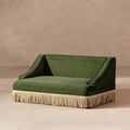 Olive green performance velvet pet sofa with elegant sloping arms and a decorative cream rope fringe skirt base.