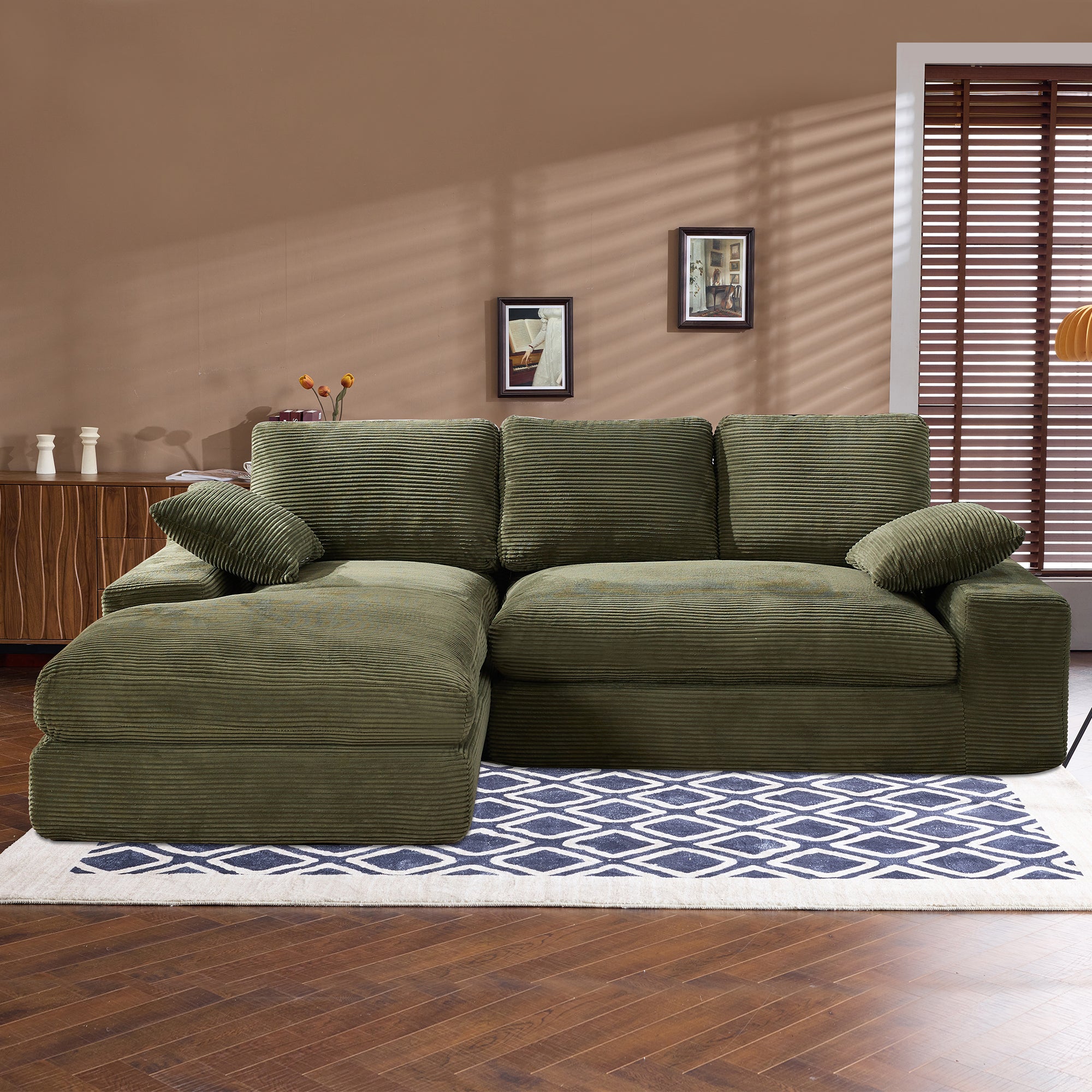 Green corduroy sofa with foam cushions and pillows, placed on a patterned rug. Durable and skin-friendly fabric for daily use.