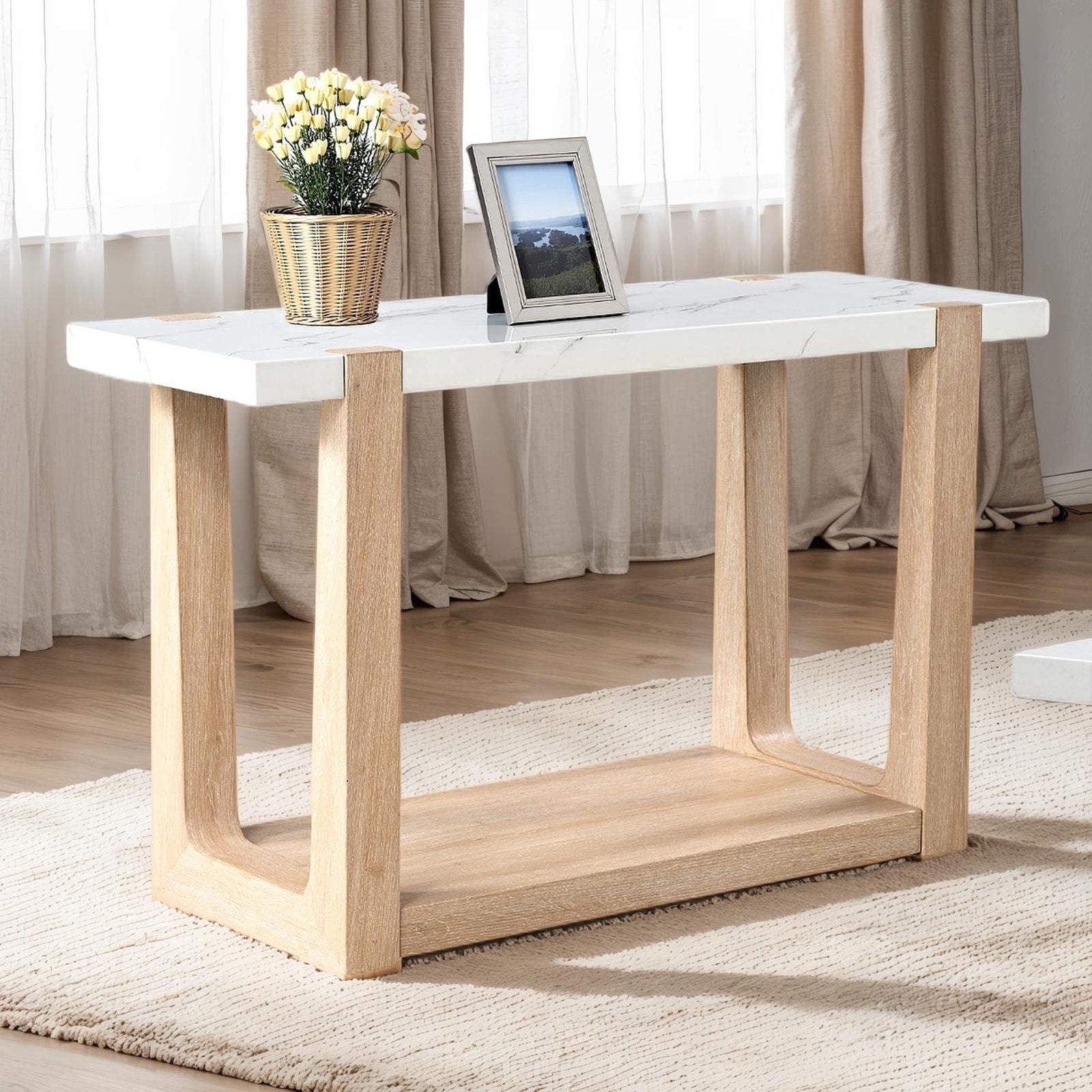 Contemporary sofa table with faux marble top in natural and white finish, styled in a bright living room with neutral decor.