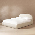 Queen platform bed in oatmeal light beige chenille, featuring a puffy, grounded design with a rounded headboard.