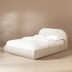 Queen platform bed in oatmeal light beige chenille, featuring a puffy, grounded design with a rounded headboard.