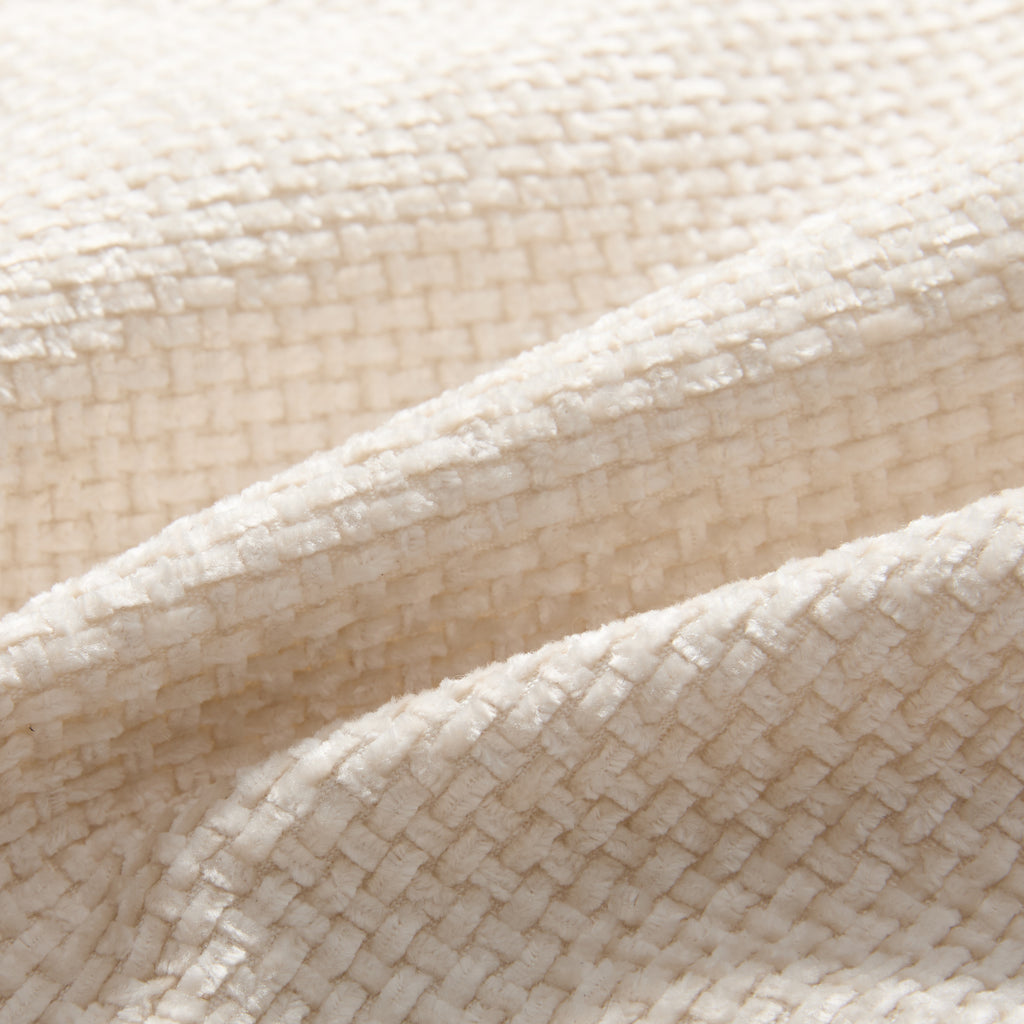 Close-up of textured cream fabric on modular sectional sofa. Durable upholstery ideal for stylish and comfortable living room use.