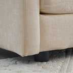 Close-up of black sofa leg and textured beige chenille upholstery. Durable base supports the modern sectional sofa design.