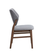 Side profile of Sarha dining chair showing padded seat and ergonomic backrest with walnut legs.