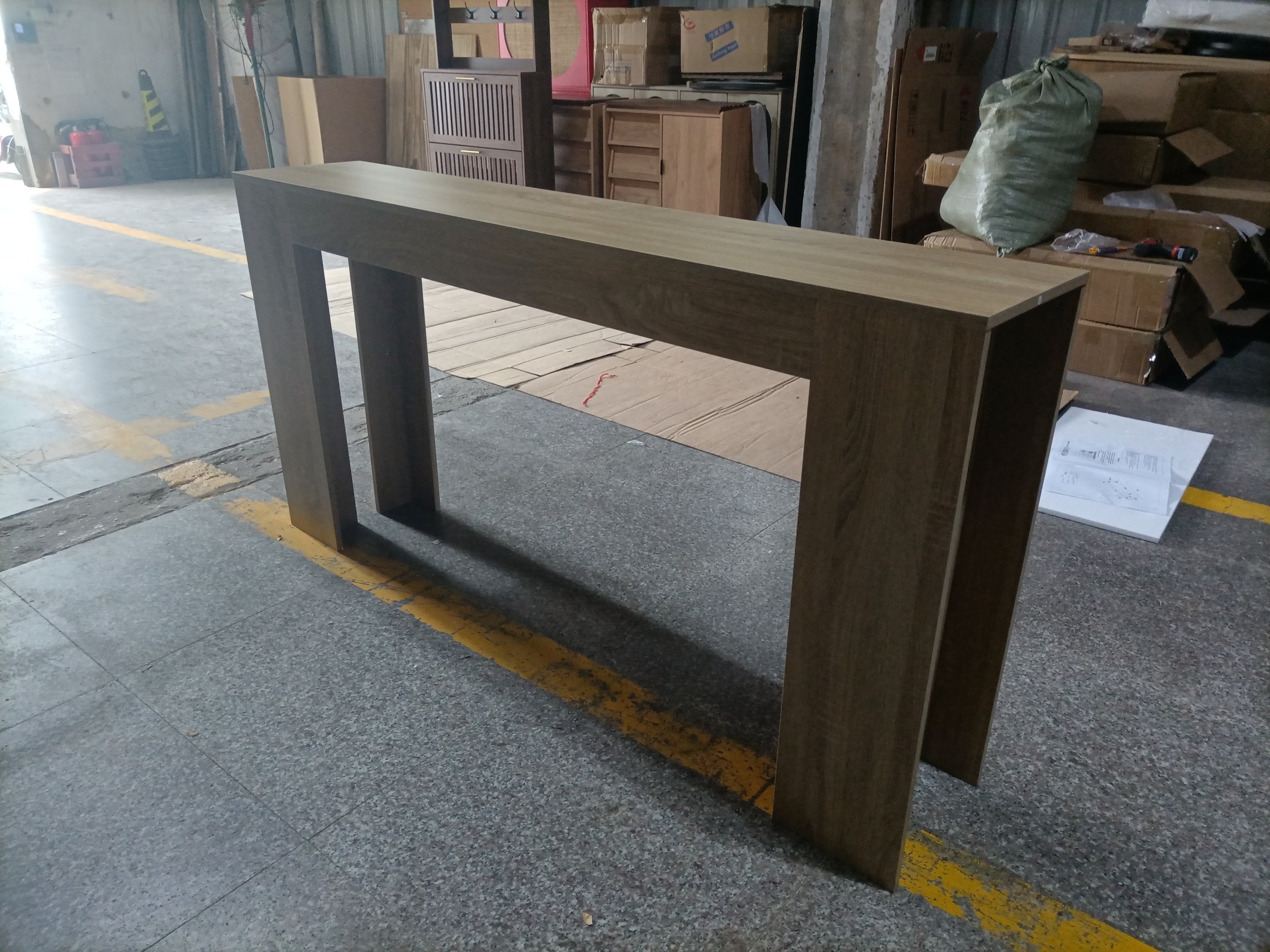 Farmhouse Oak Console Table - Extra-Long Entryway Table assembled in warehouse setting, showcasing its sturdy build and oak finish.