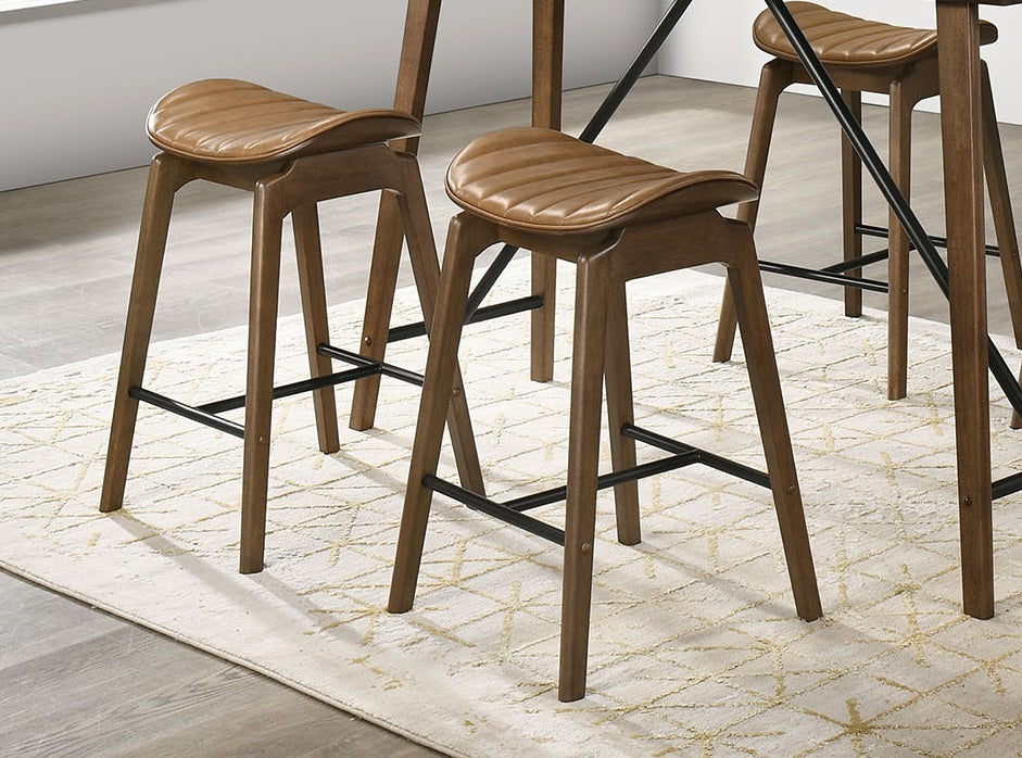 Set of Mid-Century Modern walnut counter chairs with padded saddle seats, styled around a kitchen island for a cohesive dining setup.