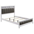White Eastern king bed frame with tufted dark leatherette panels, metallic accents, and wood construction.