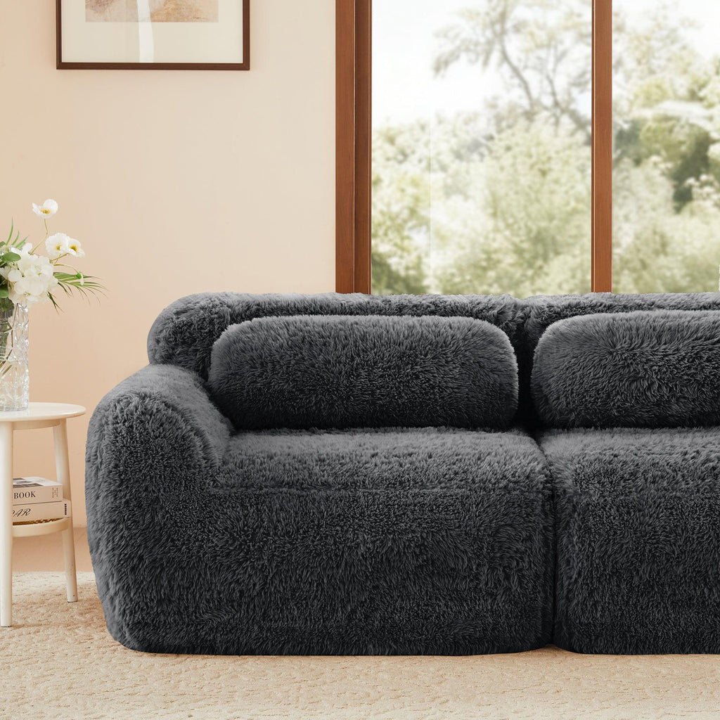 Modular Plush Sofa - Dark Grey placed in a bright living room. Features soft backrest and modern, cozy design.