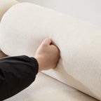 Hand pressing into the backrest of the Evelyn chenille sectional sofa, demonstrating its plush and supportive cushioning.