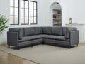 Modern dark gray linen sectional sofa with plush cushions and slim black metal legs in a bright living room.