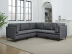 Modern dark gray linen sectional sofa with plush cushions and slim black metal legs in a bright living room.