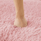 Hand pressing into soft pink plush fabric of modular sofa, demonstrating its ultra-comfortable and supportive cushioning.