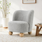 Gray boucle accent chair with curved back and wooden ball legs in a modern living room, blending comfort and style.
