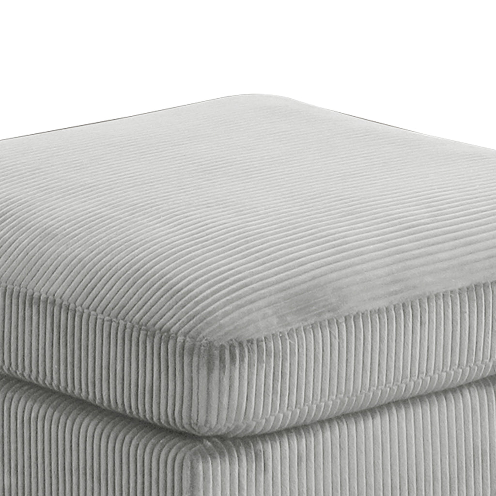 Close-up of Bentley Modular Sectional Sofa ottoman cushion in gray corduroy, highlighting soft ribbed fabric and thick padding.