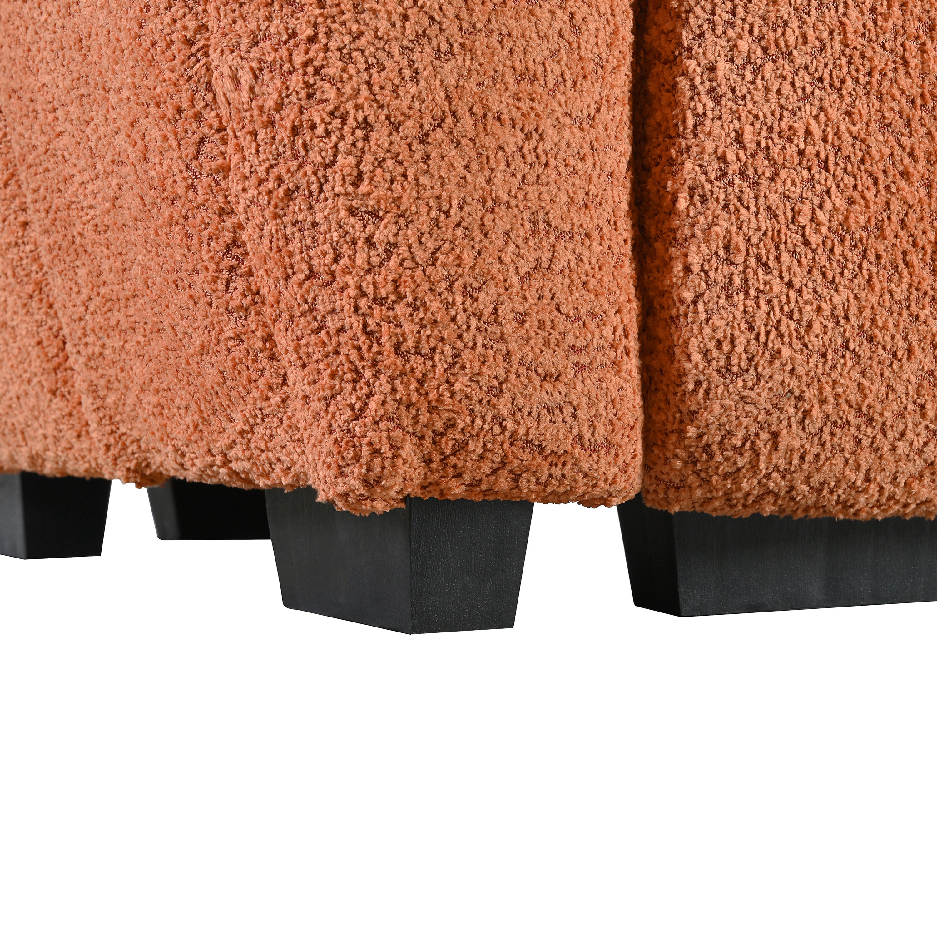 Close-up of boucle fabric texture and black plastic legs on the modular sectional sofa with ottoman, emphasizing durability and style.