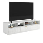 Angled view of White Coastal Credenza with TV and decor, showing functional open shelves and sleek drawer fronts.