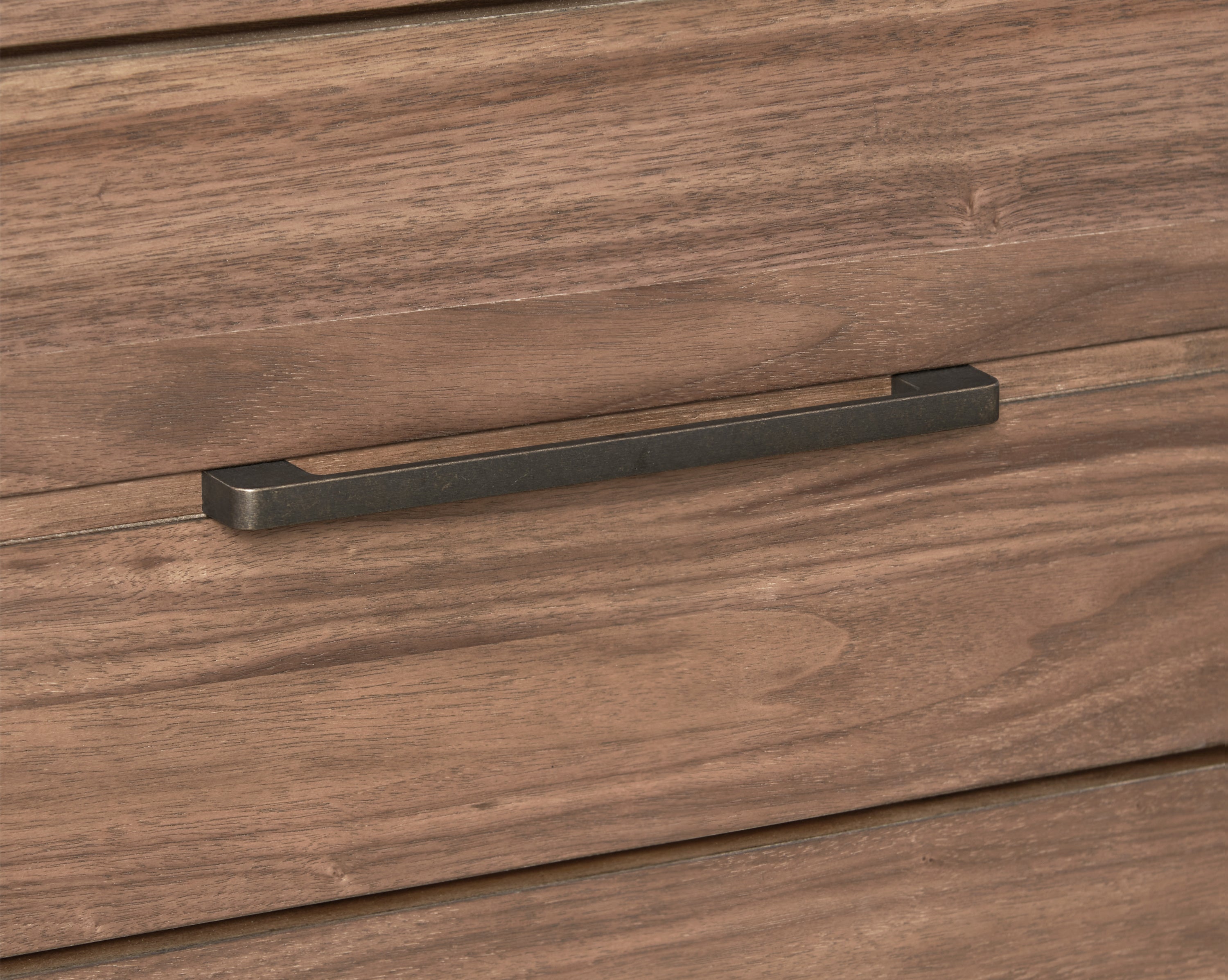Close-up of metal drawer handle on walnut finish chest. Durable hardware enhances the 5-drawer Tranquility Collection chest.