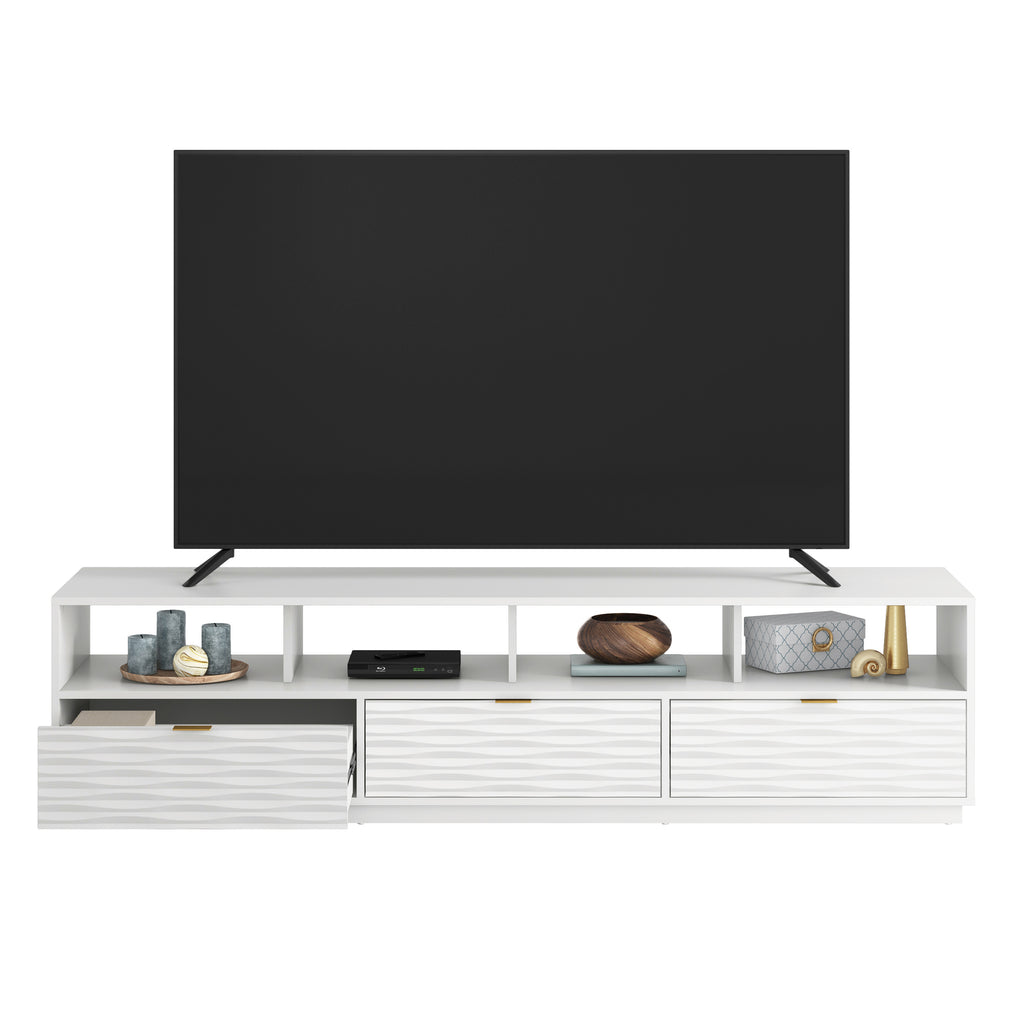 White media console with one drawer open, displaying organized storage space for blankets and accessories under a mounted TV.