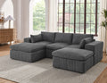 Modular sectional with ottomans in dark gray corduroy fabric placed in a bright living room. Features large arms and customizable layout.