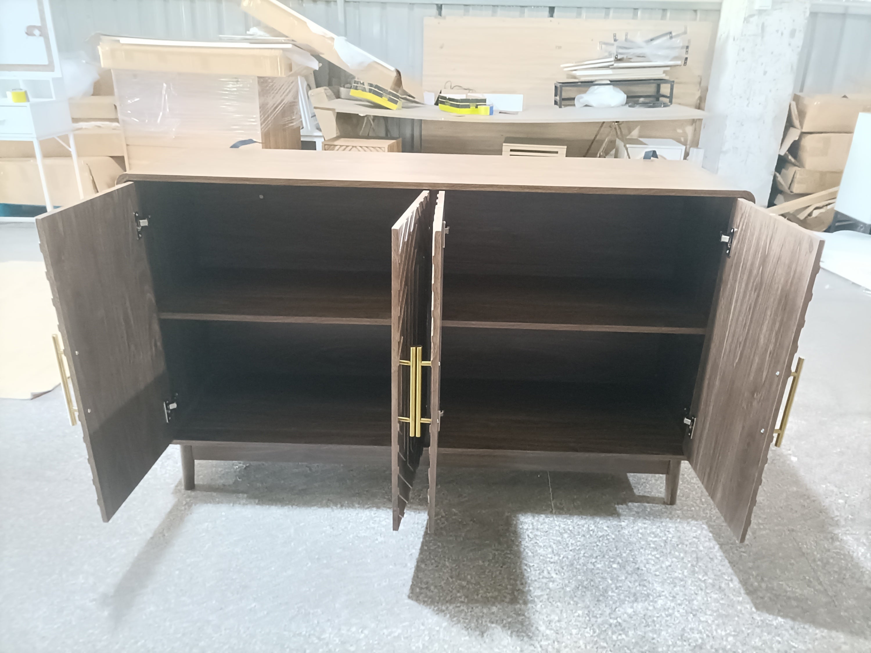 Interior view of walnut sideboard with doors open, revealing adjustable shelves for versatile storage in a modern dining space.