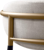 Close-up of the gold metal frame and textured beige upholstery on the backrest of a contemporary counter height chair.