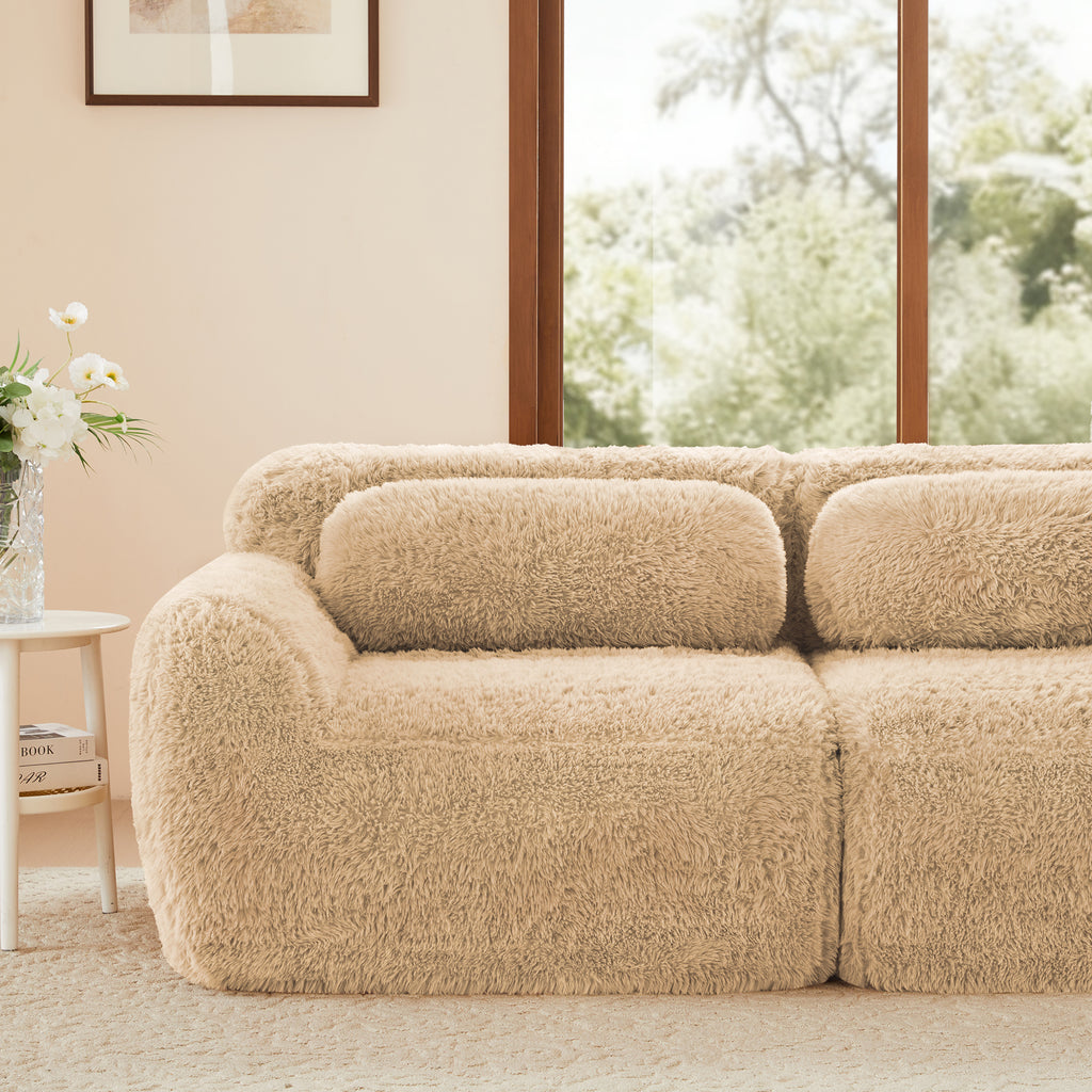 Close-up of left side of plush fabric modular sectional sofa. Features soft backrest and armrest for added comfort.