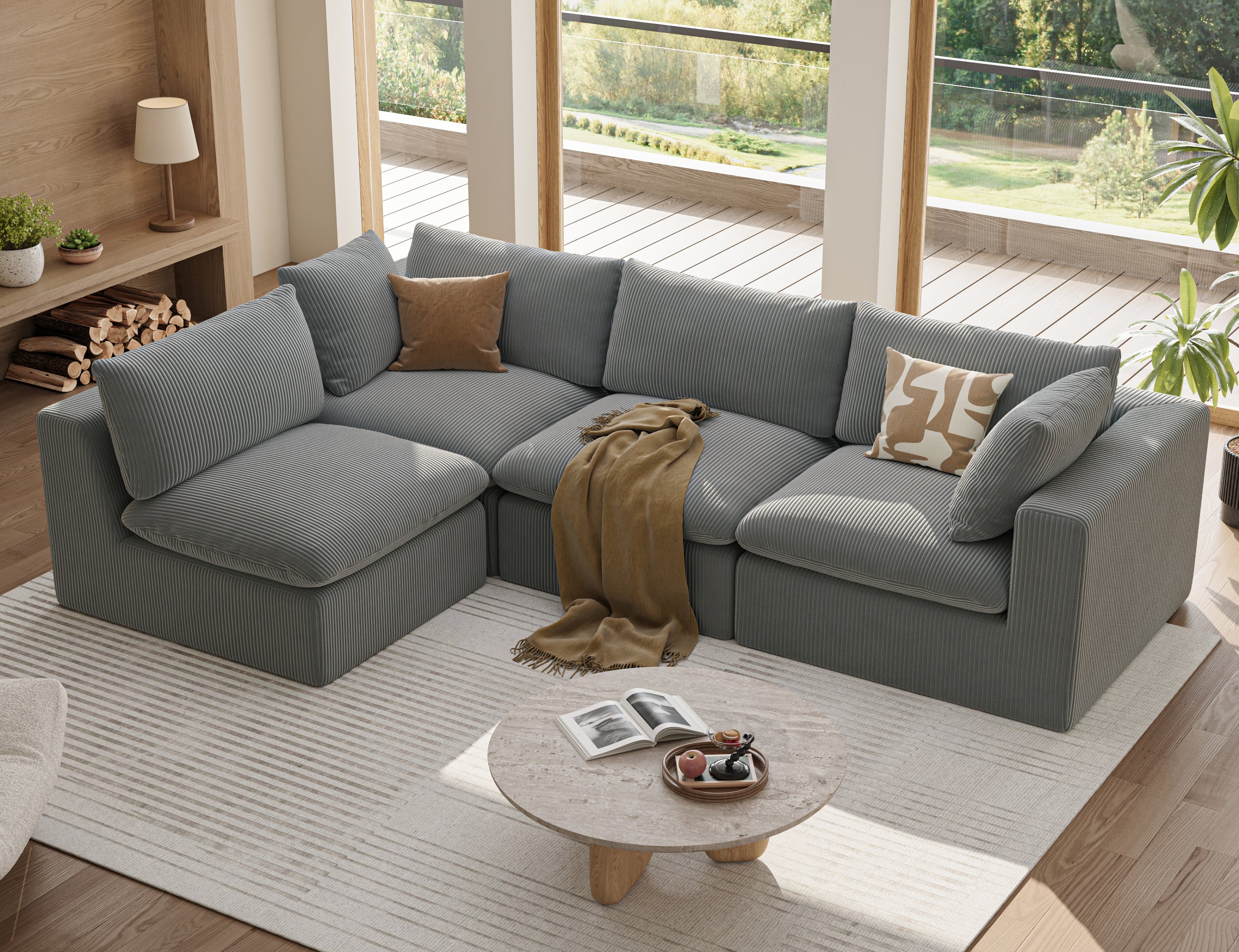Oversized 4-seater modular L-shaped sectional in grey corduroy fabric with two decorative pillows and a throw blanket.