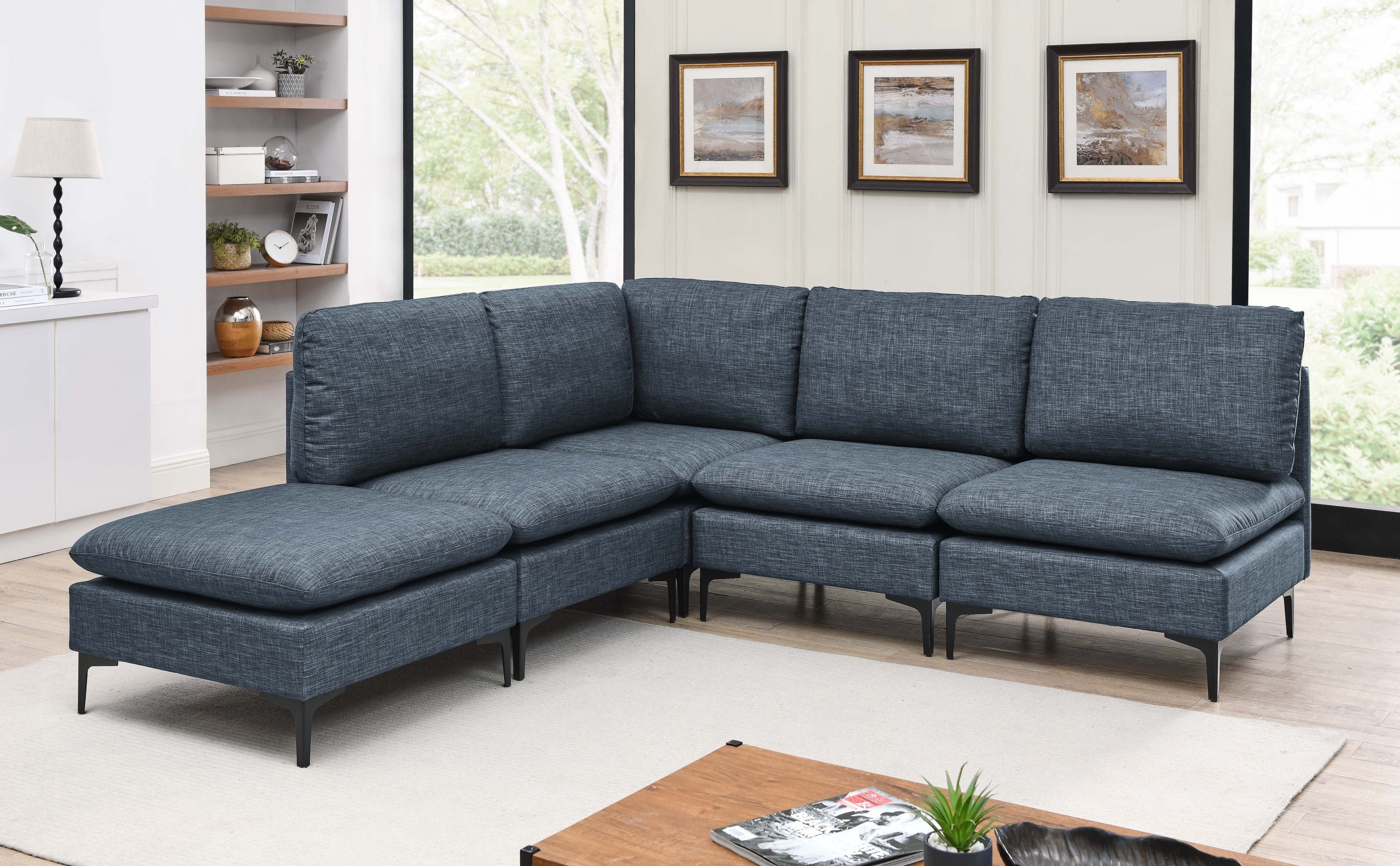 Modern blue linen modular sectional sofa featuring plush cushions and sleek black metal legs in a contemporary living room.