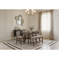 Brown bar-height dining set with marble-look top, fabric-upholstered stools, and a matching bench in a classic room.