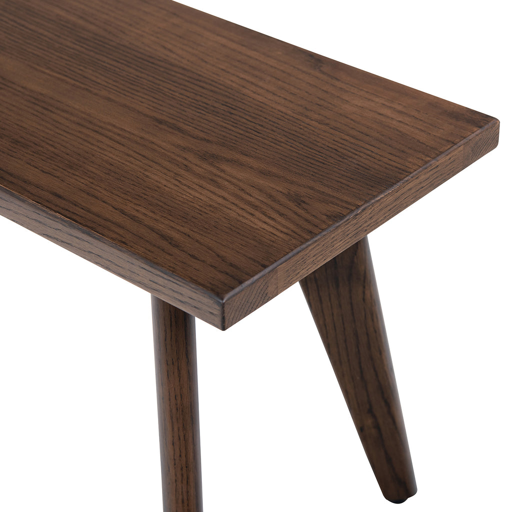Close-up of Capri bench top showcasing dark brown red oak wood grain. Smooth finish highlights handcrafted quality.