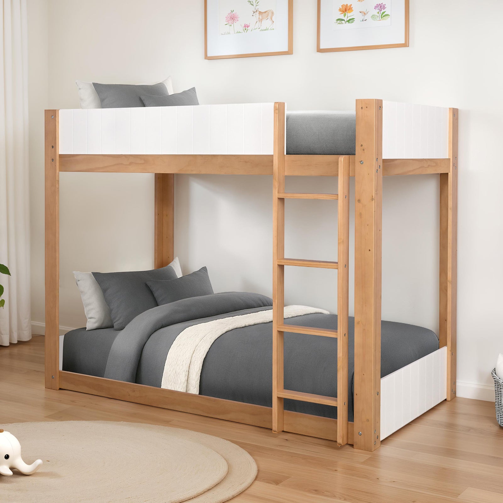 Modern twin over twin bunk bed featuring a white panel design and durable wood frame, styled with gray bedding in a cozy room setting.
