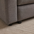 Close-up of sofa leg and fabric texture on modular sofa with ottoman, showing sturdy black legs and durable upholstery.