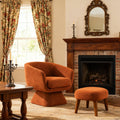 Modern Accent Chair with Ottoman in burnt orange fabric placed by a fireplace, ideal for cozy reading and stylish home decor.