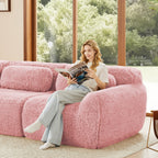 Woman reading on ergonomic pink sofa chaise with plush fabric, showcasing modular design and comfort in a bright living room.