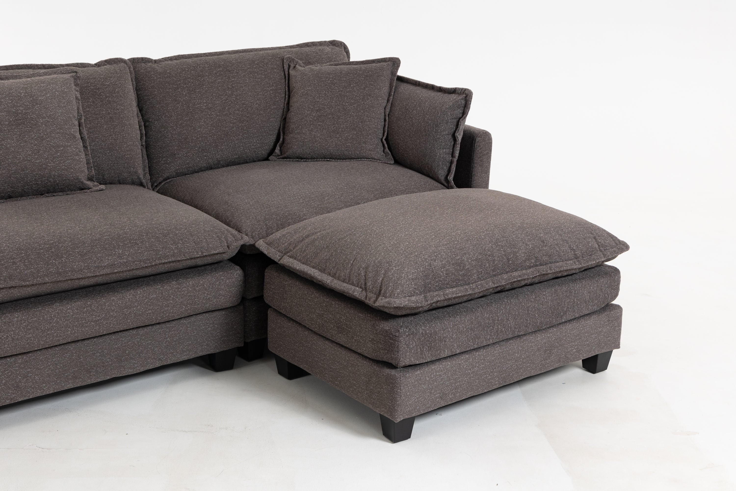 Close-up of Ottoman and corner of Sectional Sofa. Thick cushion and soft chenille upholstery highlight comfort and durability.