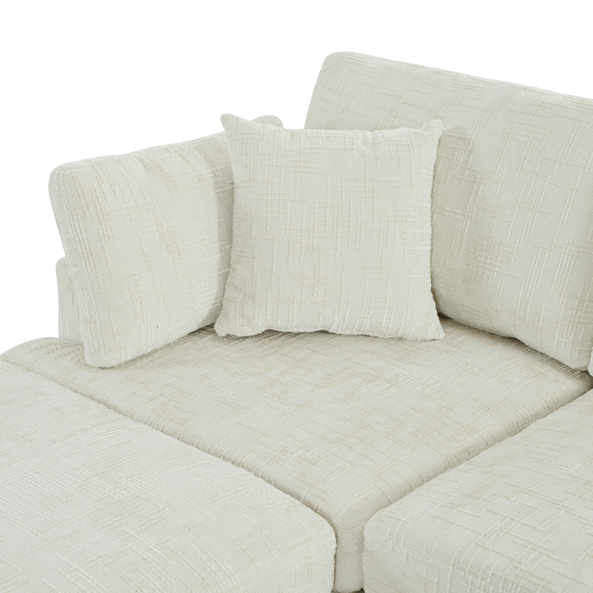 Close-up of U-shaped sectional sofa with ottoman in plush chenille fabric, showcasing modular cushions and included throw pillow.
