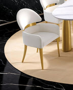 Contemporary Dining Arm Chairs in White and Gold placed around a modern dining table with black marble and beige rug accents.