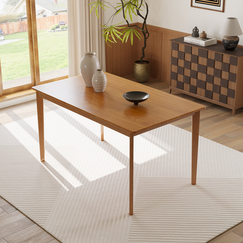 Solid wood dining table in a sunlit room with decorative vases. Highlights the elegant wood grain and minimalist design.