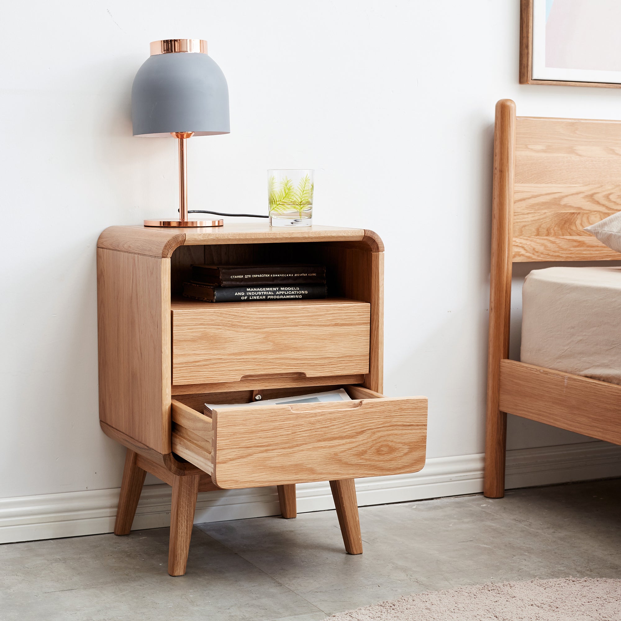 Solid Wood Bedside Cabinet - Organized Storage with drawers open beside bed, styled with lamp and glass for bedroom use.