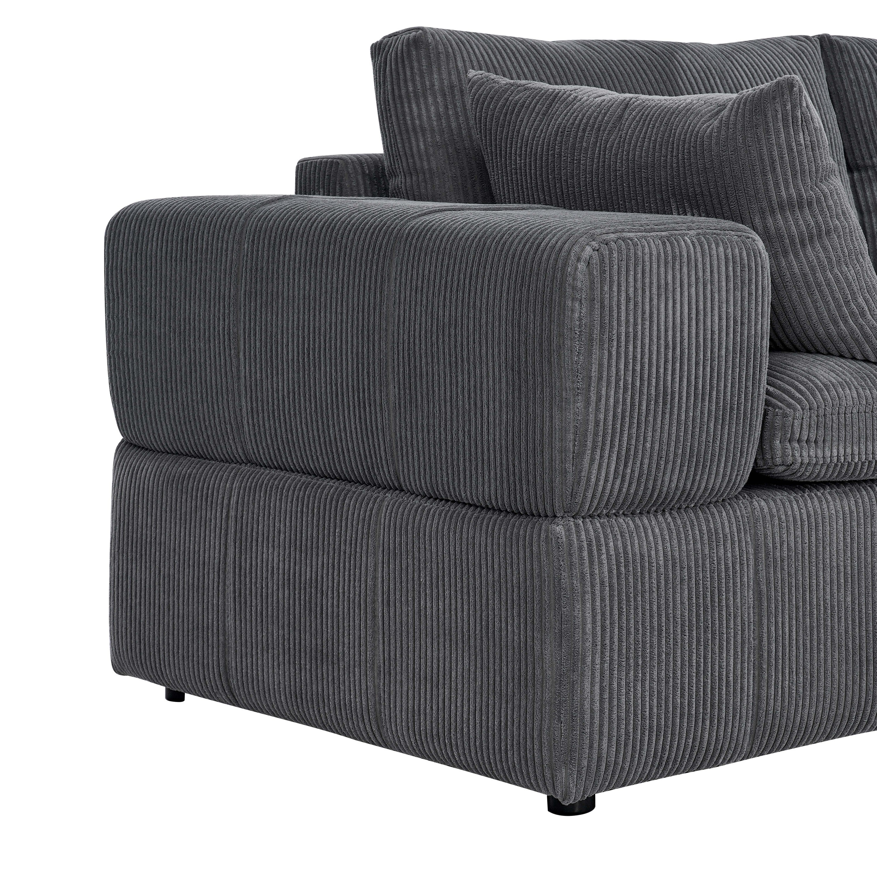 Detail of the wide armrest and cushion on the corduroy sectional. Emphasizes soft padding and ribbed fabric texture.