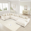Oversized cream corduroy modular sectional sofa with extra-wide armrests and plush cushions in a bright living room.