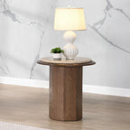 Kasha Walnut Travertine End Table with round travertine top and wooden base, styled with lamp and plant in modern living room.