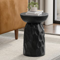 Black round accent table made of solid mango wood, featuring a textured, carved pedestal base and a smooth top.