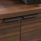 Detail of the matte black metal handles on the Library Base, Brown finish cabinet, blending style with functionality.