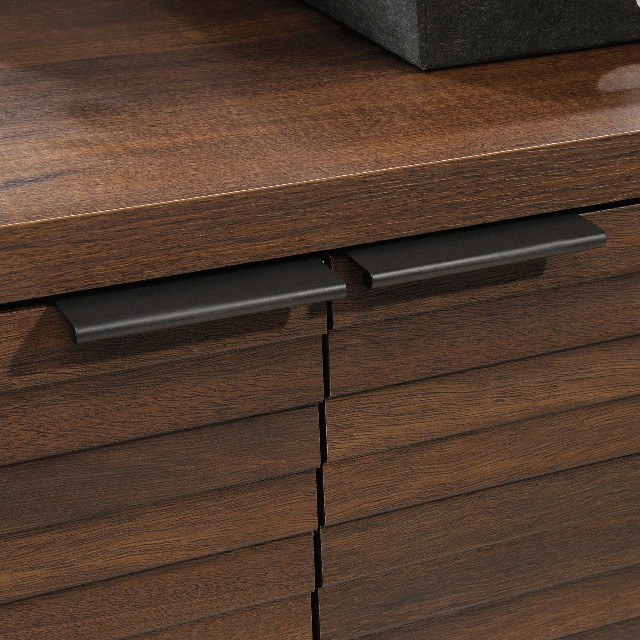 Detail of the matte black metal handles on the Library Base, Brown finish cabinet, blending style with functionality.
