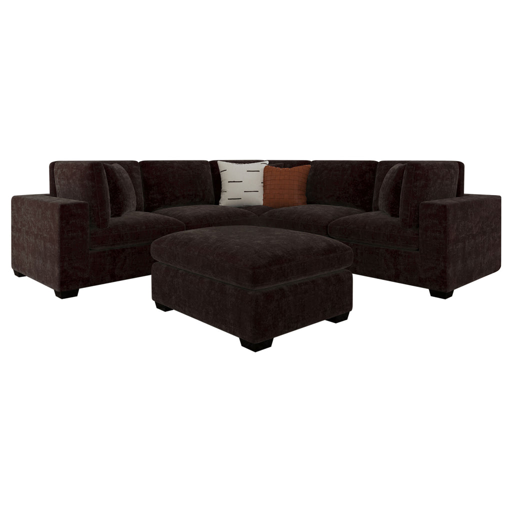 Dark chocolate 6-piece upholstered modular sectional with matching ottoman, black feet, and two decorative throw pillows.