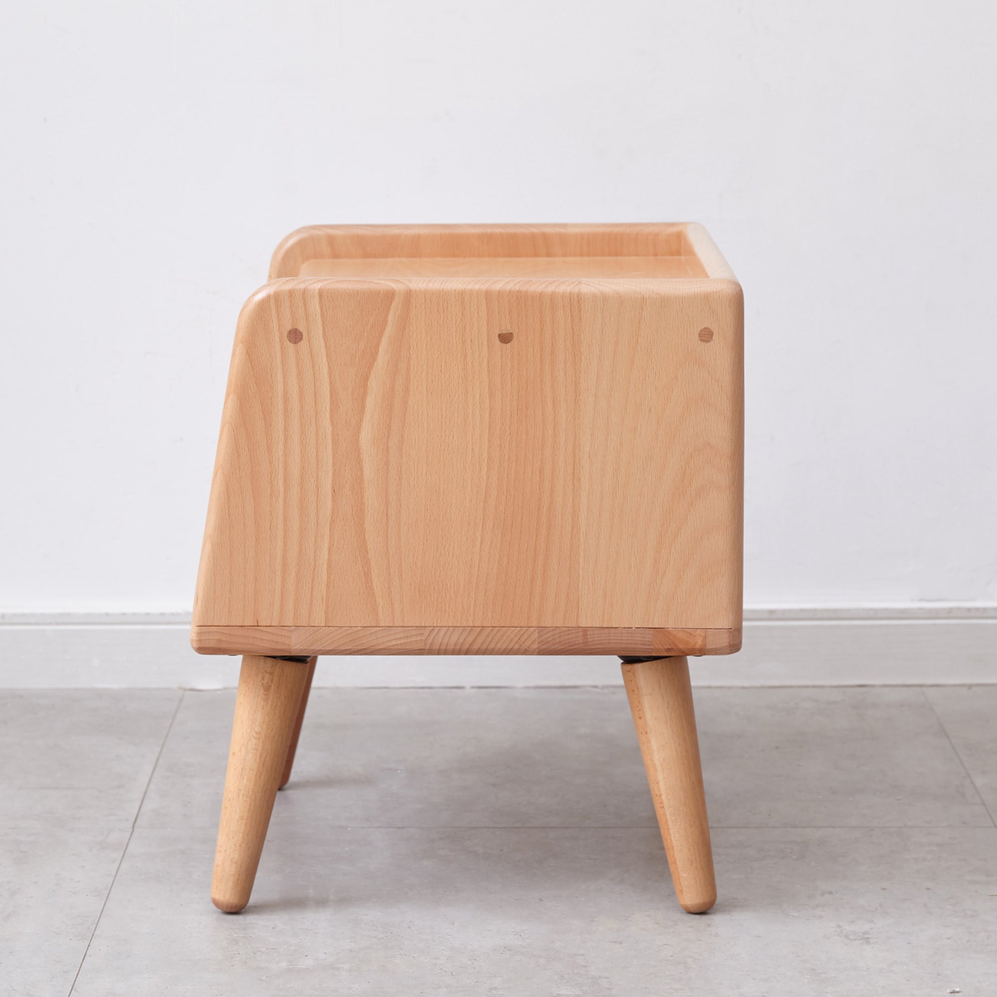 Side profile of Solid Wood Bedside Cabinet - Nordic Storage with rounded edges and tapered legs in natural beechwood.